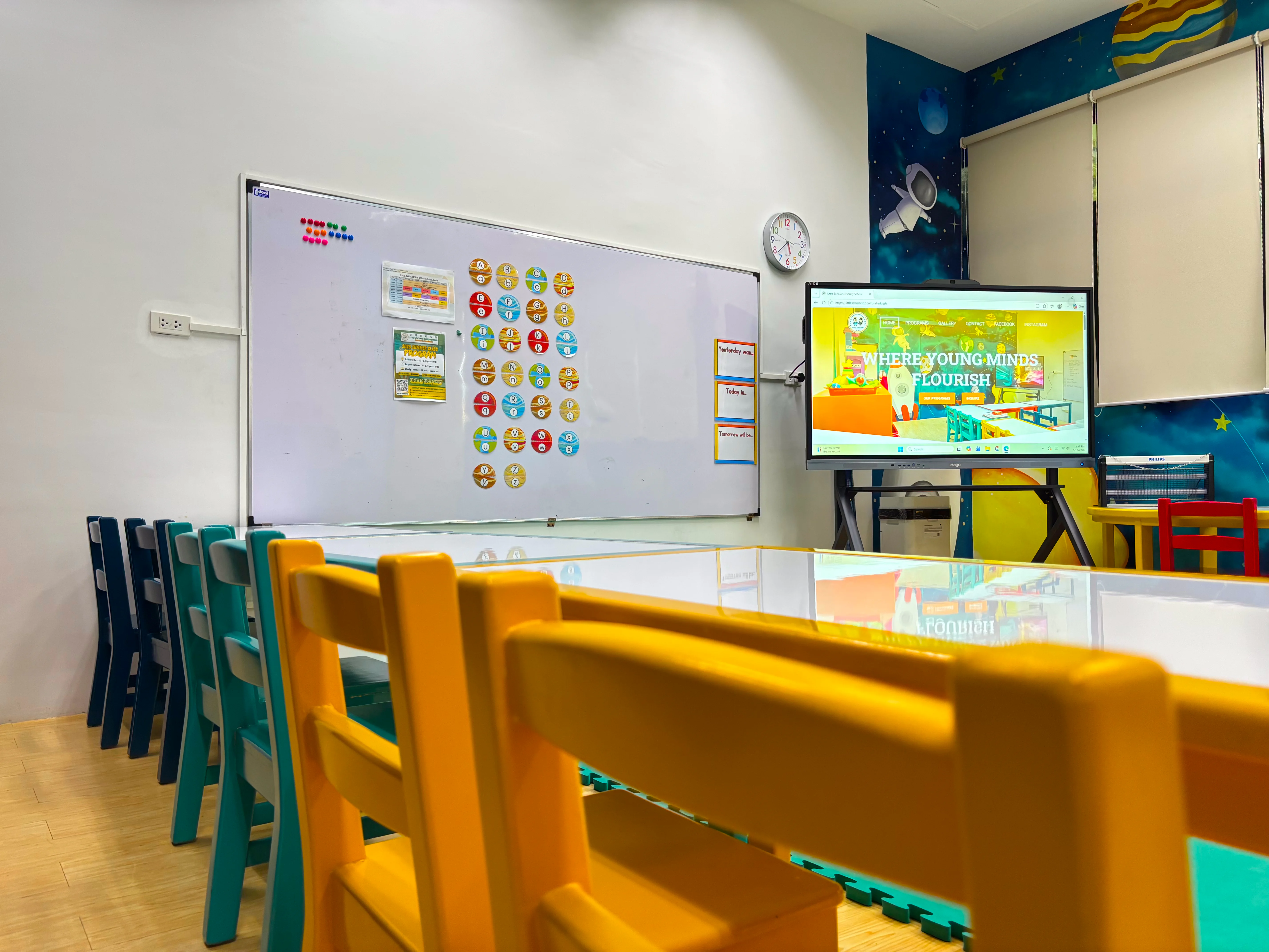 Galaxy Room with child-sized tables, learning board, and digital display